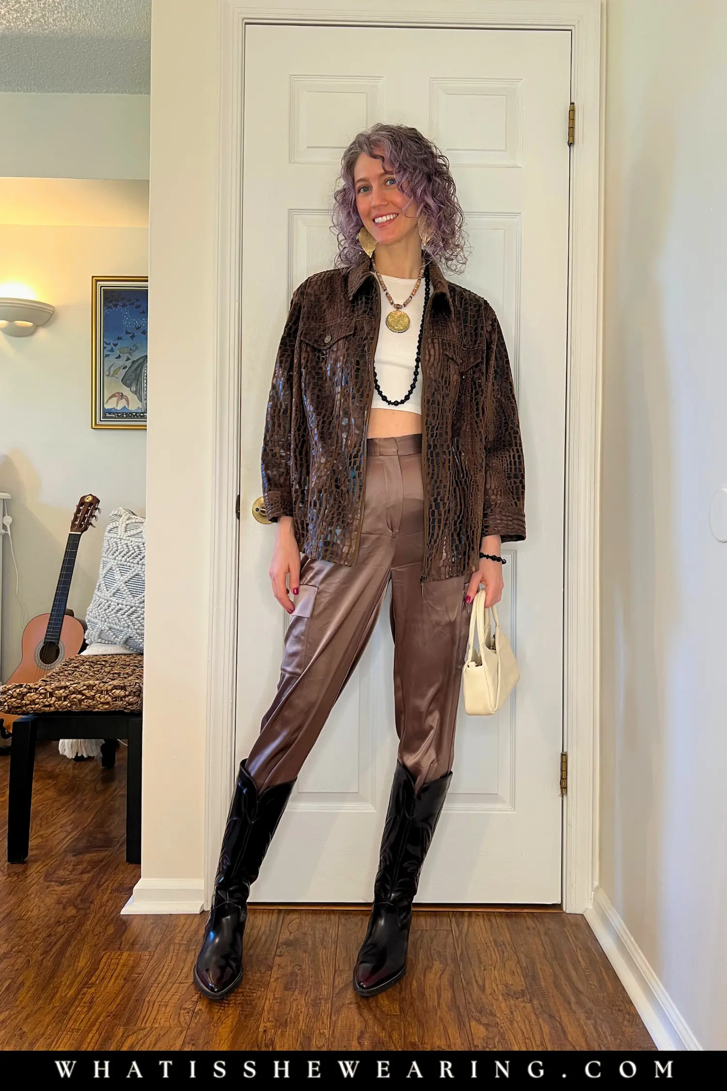 Woman in an animal print jacket and satin trousers with oxblood Zara cowboy boots, a wardrobe timeless essential.