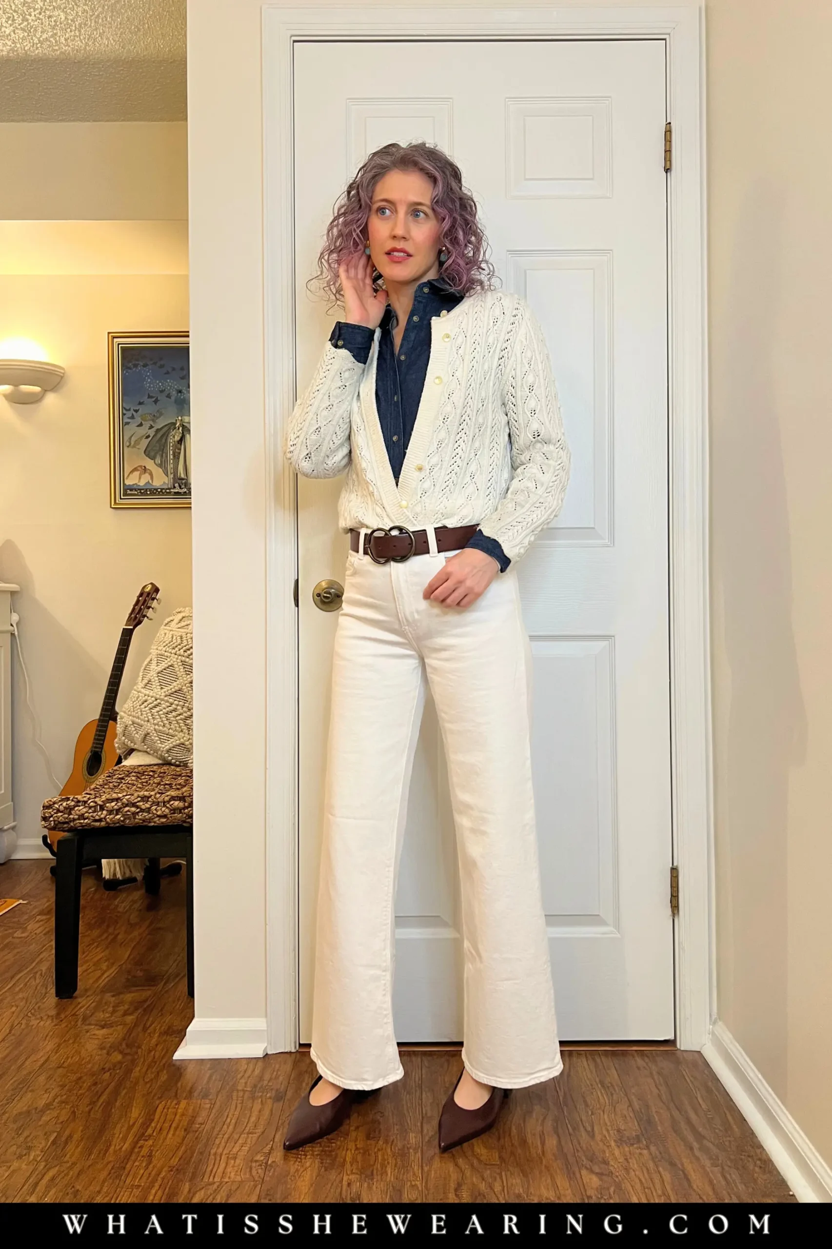 Modern denim stacking outfit with a dark shirt, white jeans, and ivory cardigan.