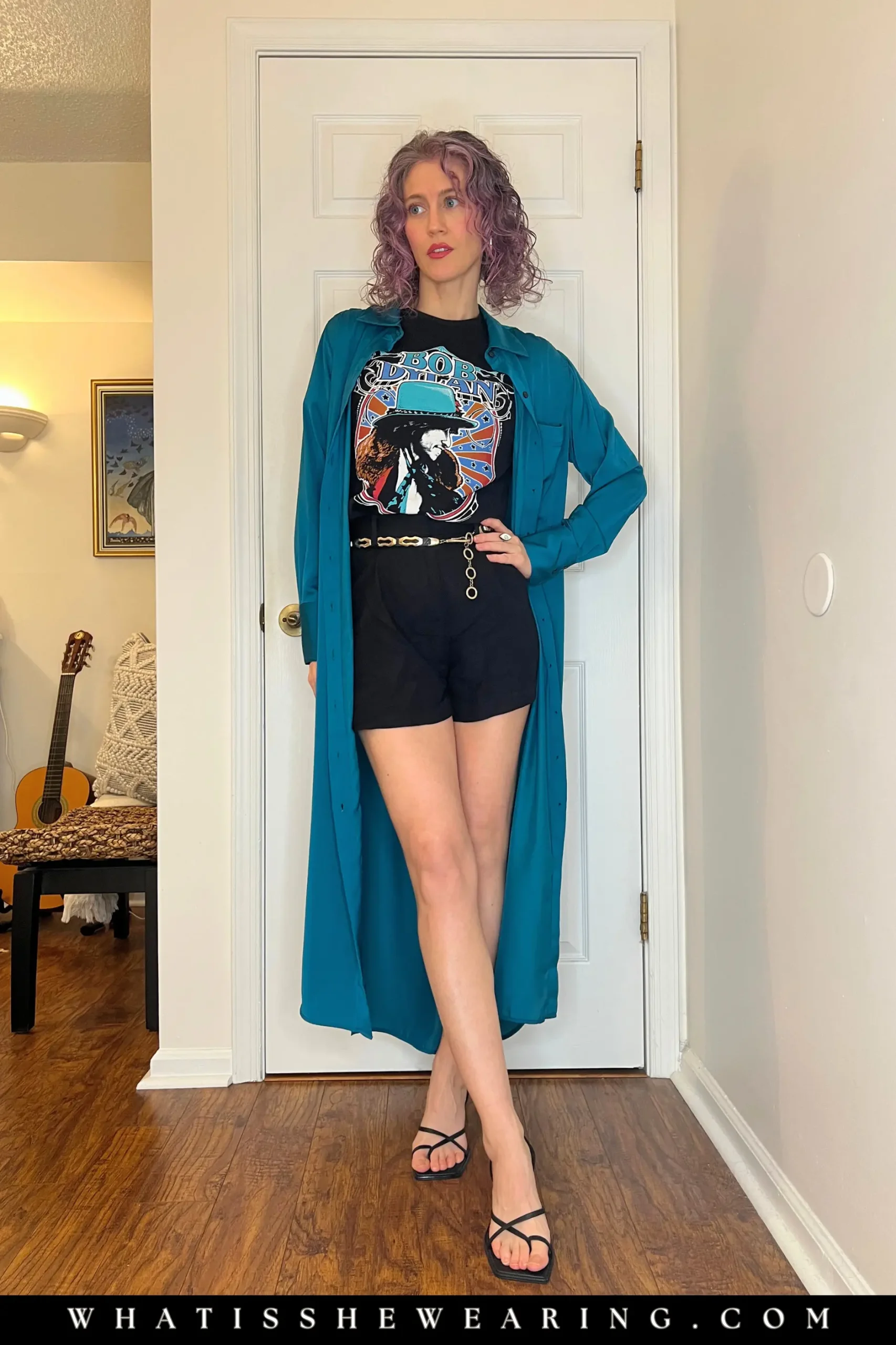 Woman modeling a Bob Dylan band tee under a satin shirt dress with linen shorts and strappy heels.