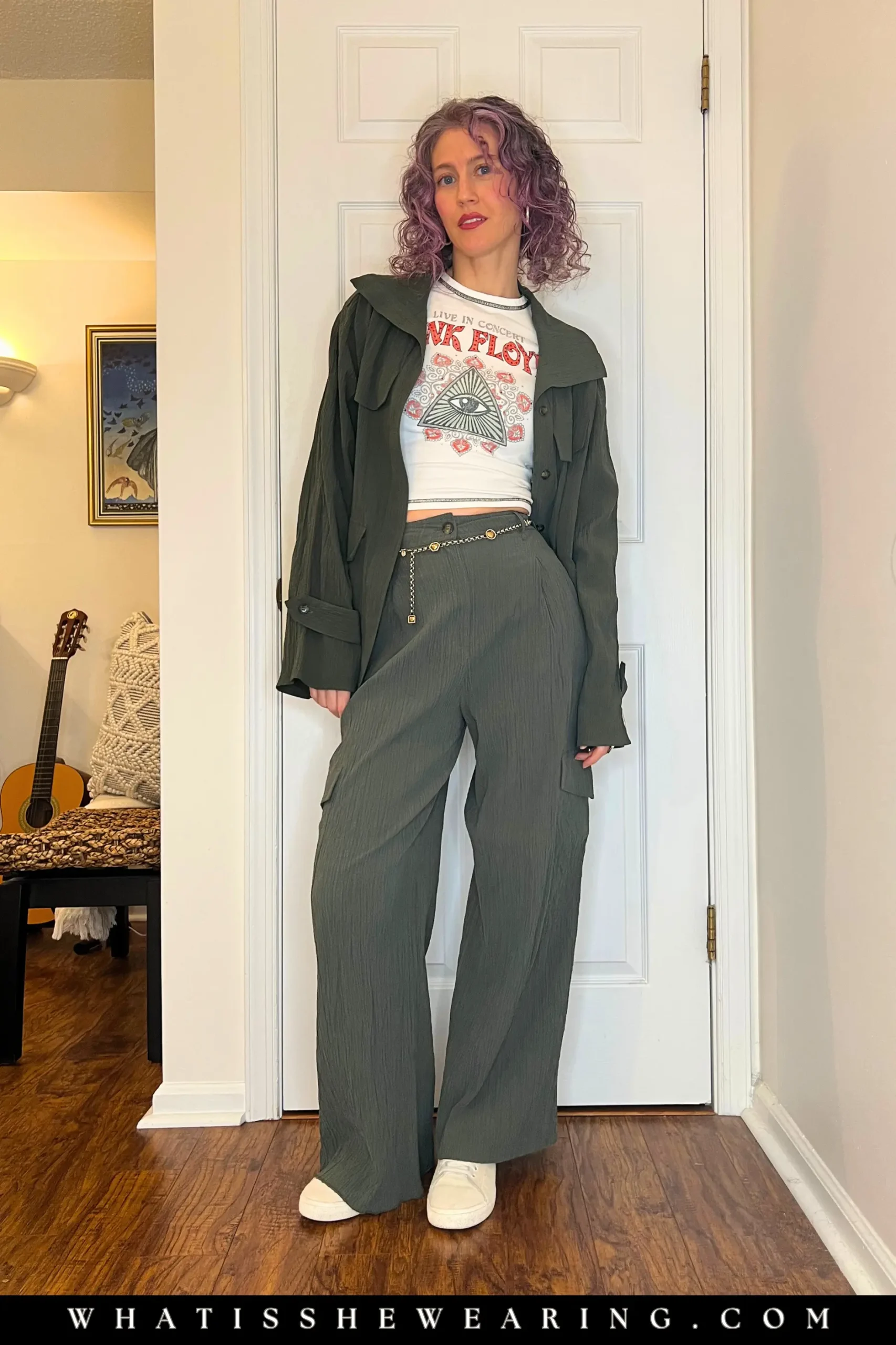 Woman modeling how to style band t-shirts with a military-inspired matching set, chain belt, and suede sneakers.