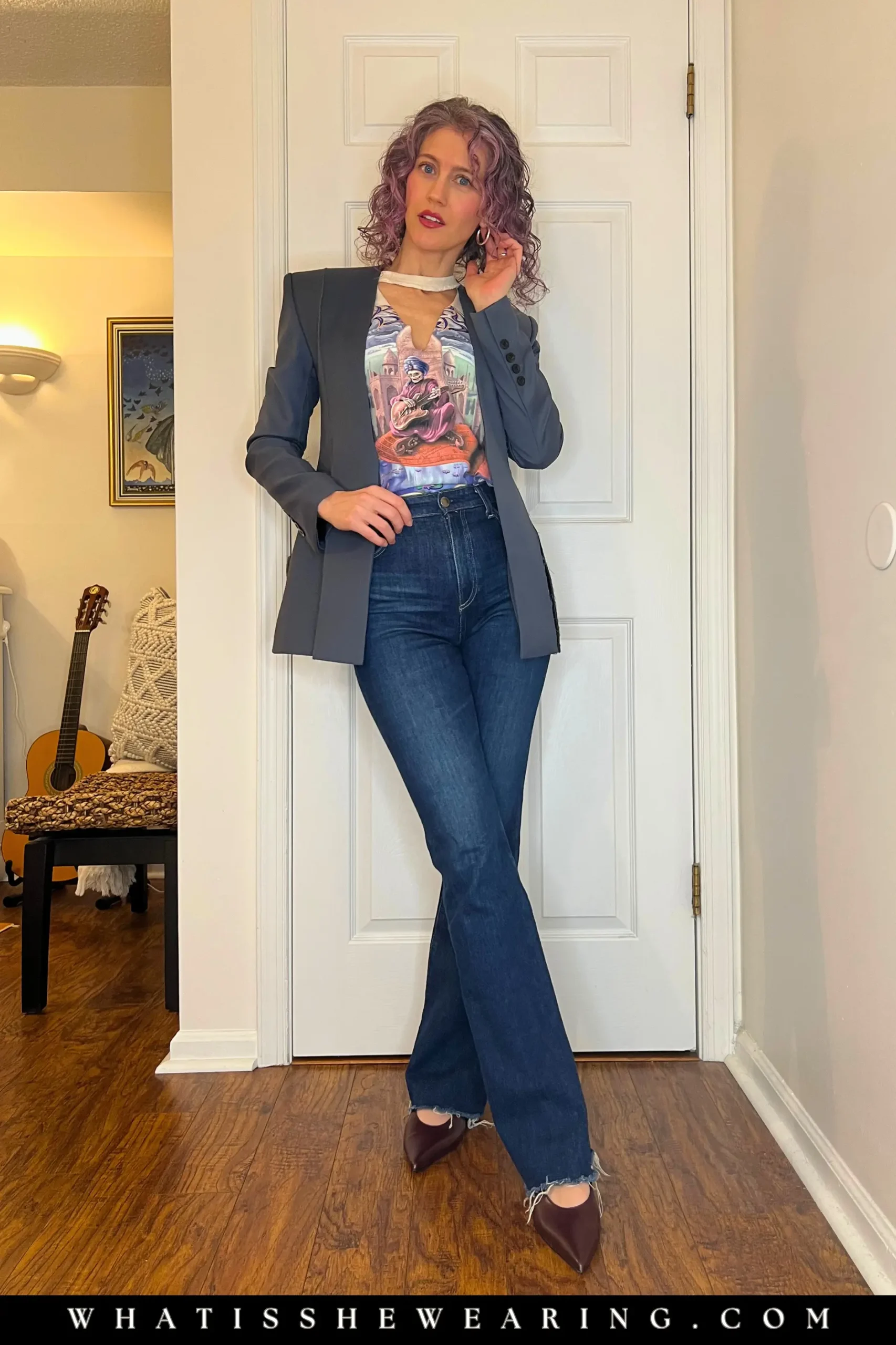 Woman showing how to style band t-shirts with a statement jacket over jeans for a concert-ready look.