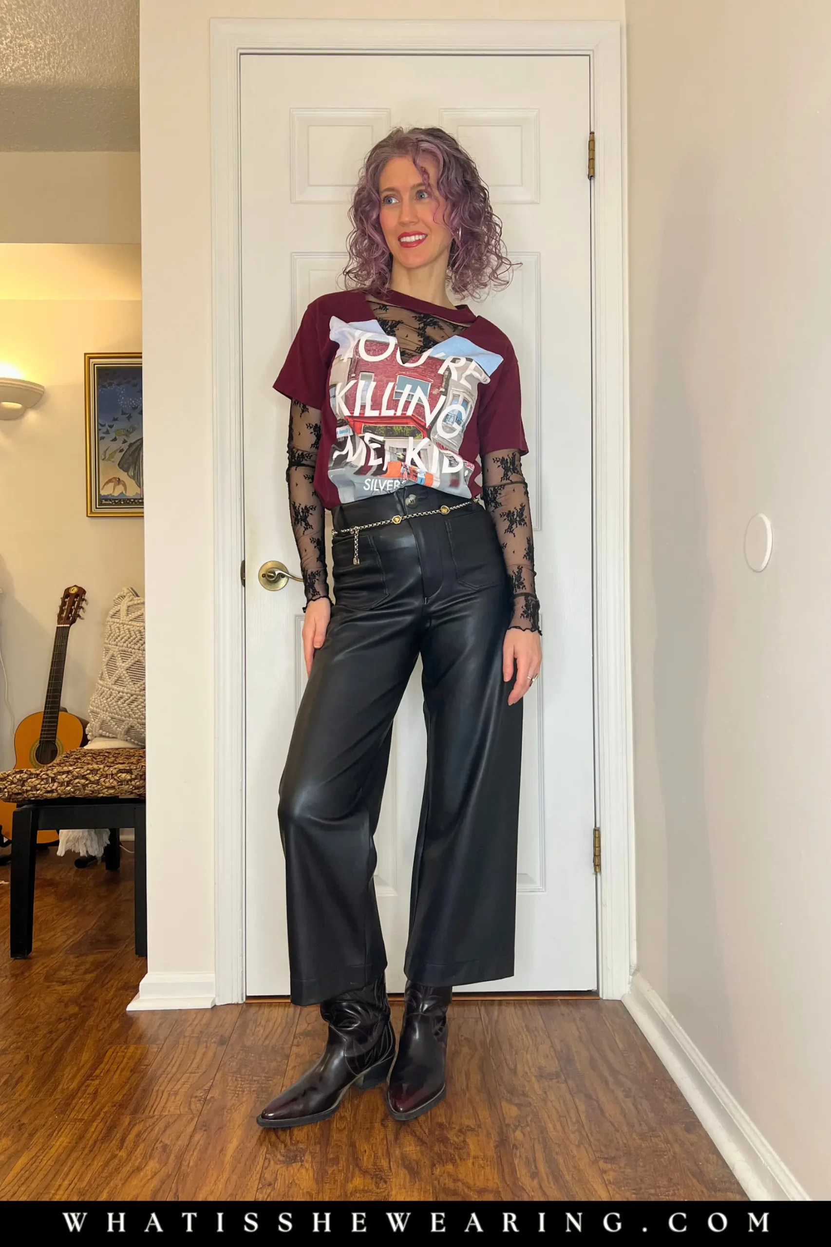 Woman modeling how to style band t-shirts with a black lace top, leather pants, and pointy-toe Western boots.