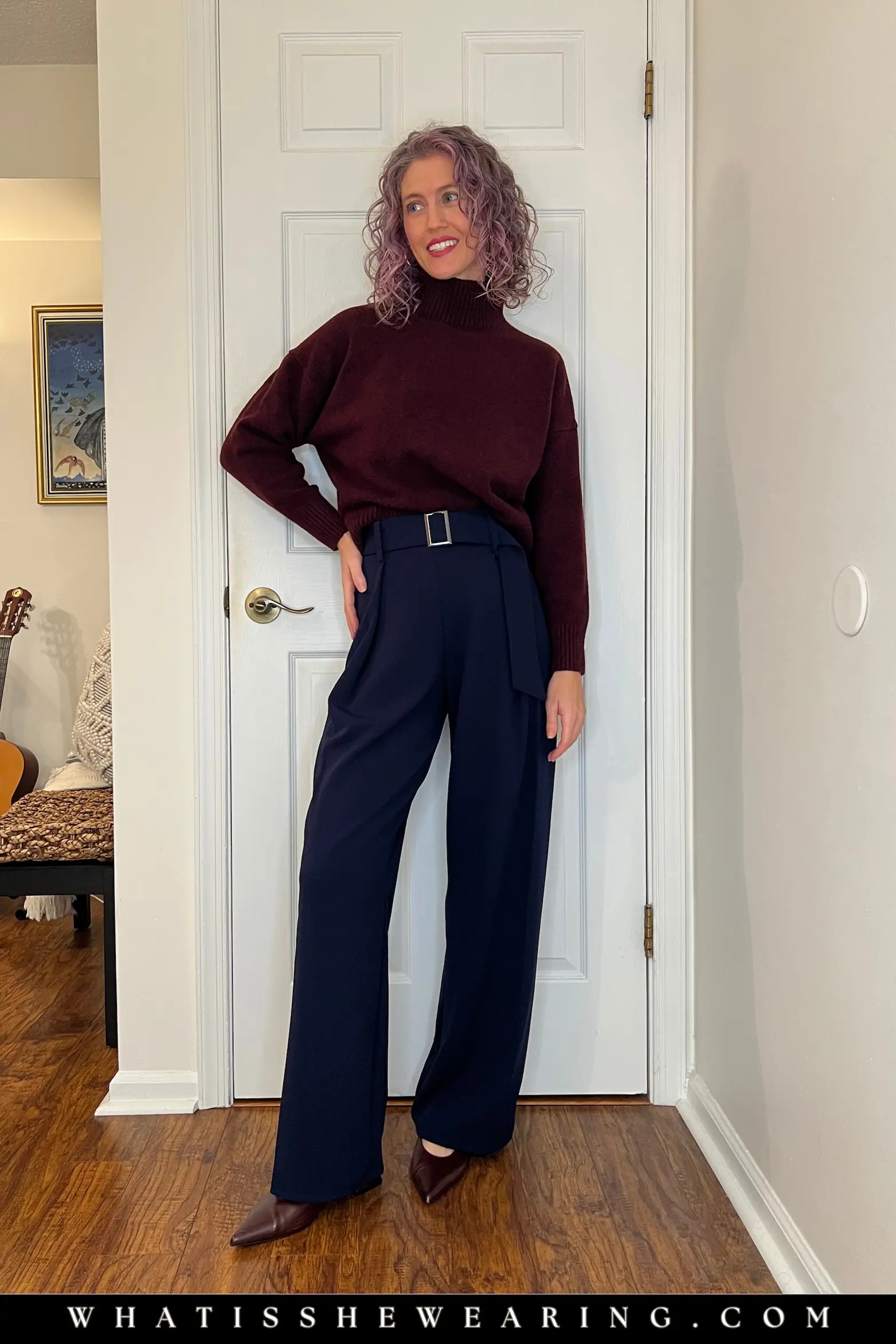 Navy Blue and Burgundy Drama Outfit Woman wearing burgundy funnel neck knit with navy blue pants—what to wear with navy blue for alluring winter drama and quiet luxury holiday outfits.