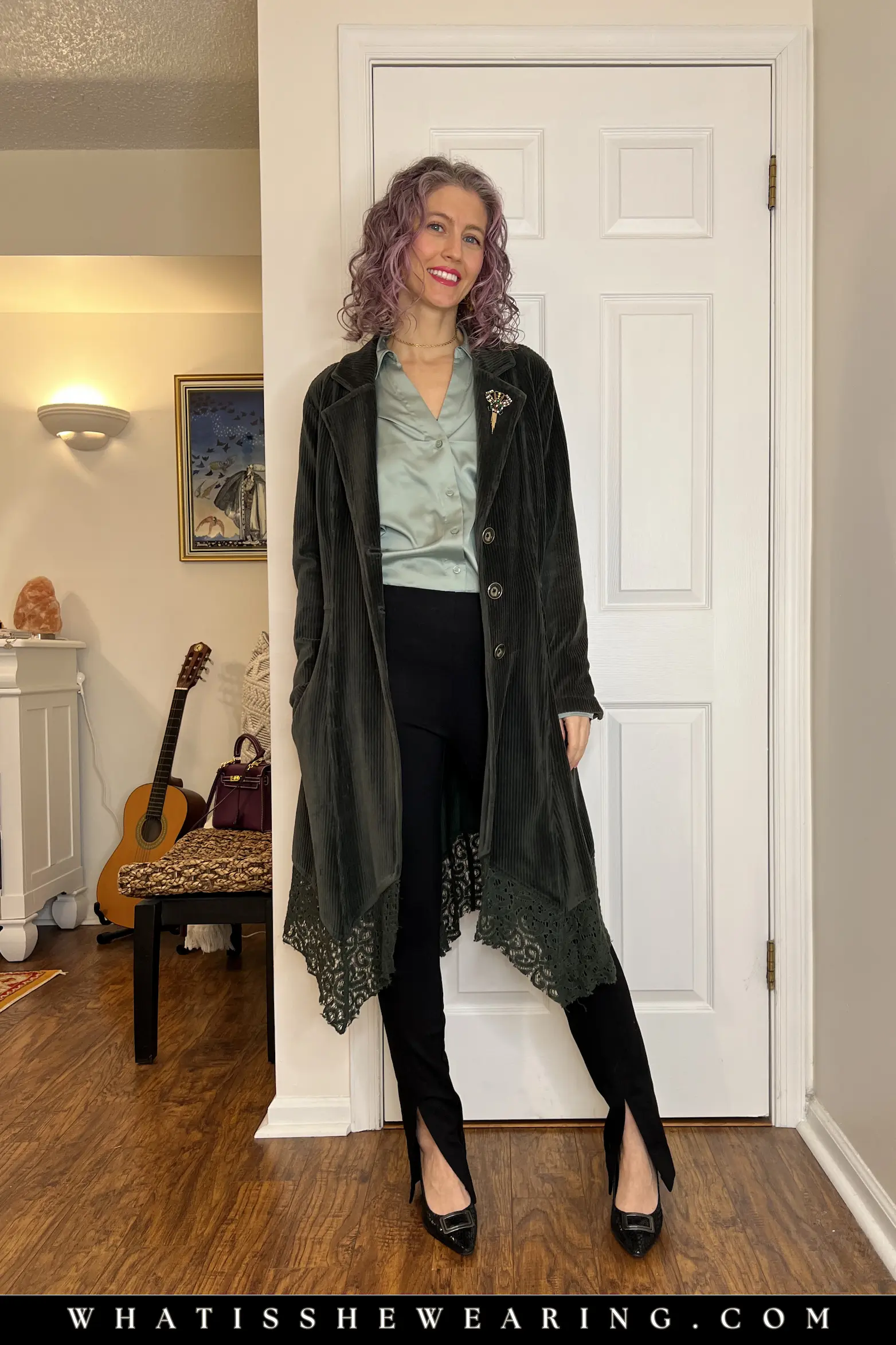 Green Velvet Trench Coat over Muted Green Silk Blouse Woman styled in muted green silk blouse, black split hem pants, pointy toe pumps, and lightweight green velvet trench coat for rainy spring days