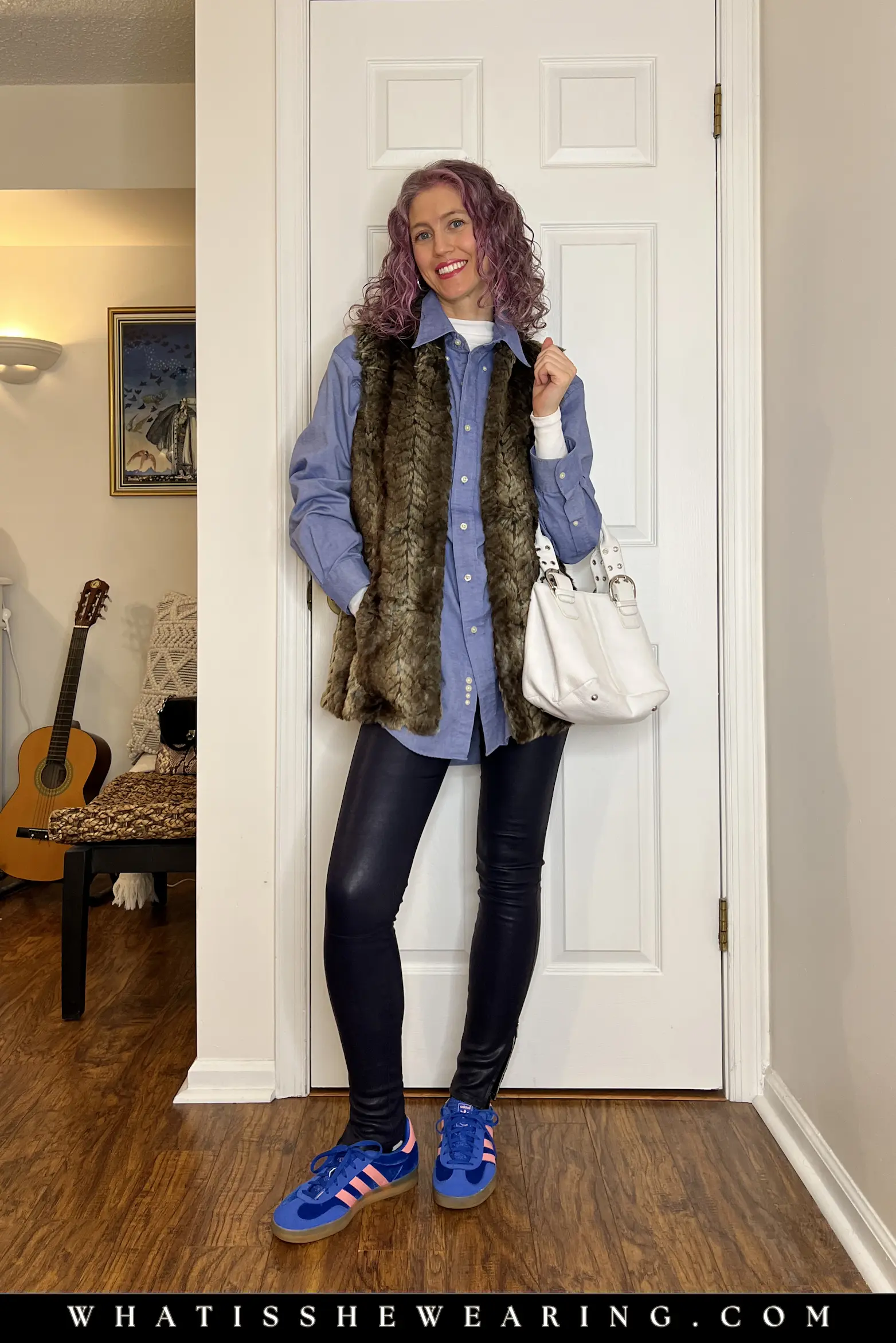 Errands-Ready Transitional Spring Outfit Casual spring transitional outfit: blue oversized button-down shirt layered with faux fur vest, navy leather leggings, colorful suede sneakers, and white leather bucket tote for busy early spring days